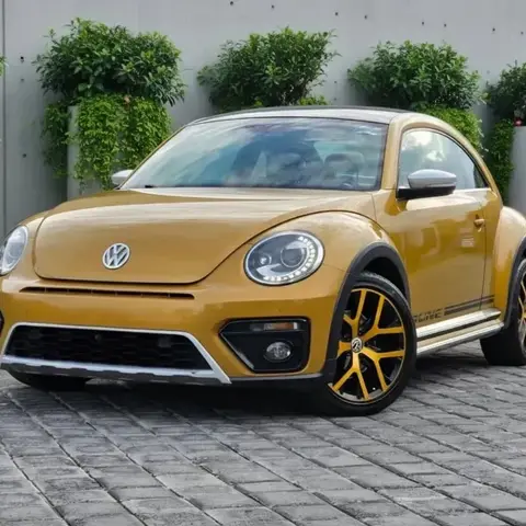 Volkswagen Beetle Dune dorado con rines personalizados