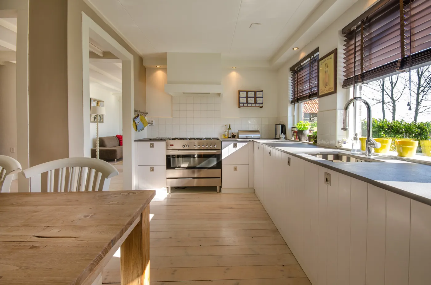 Cocina integral blanca con cubierta gris y mesa de madera